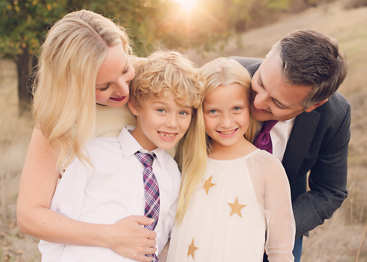 Family of four with golden backlight during a portrait session by Alicia Cervenka Photography