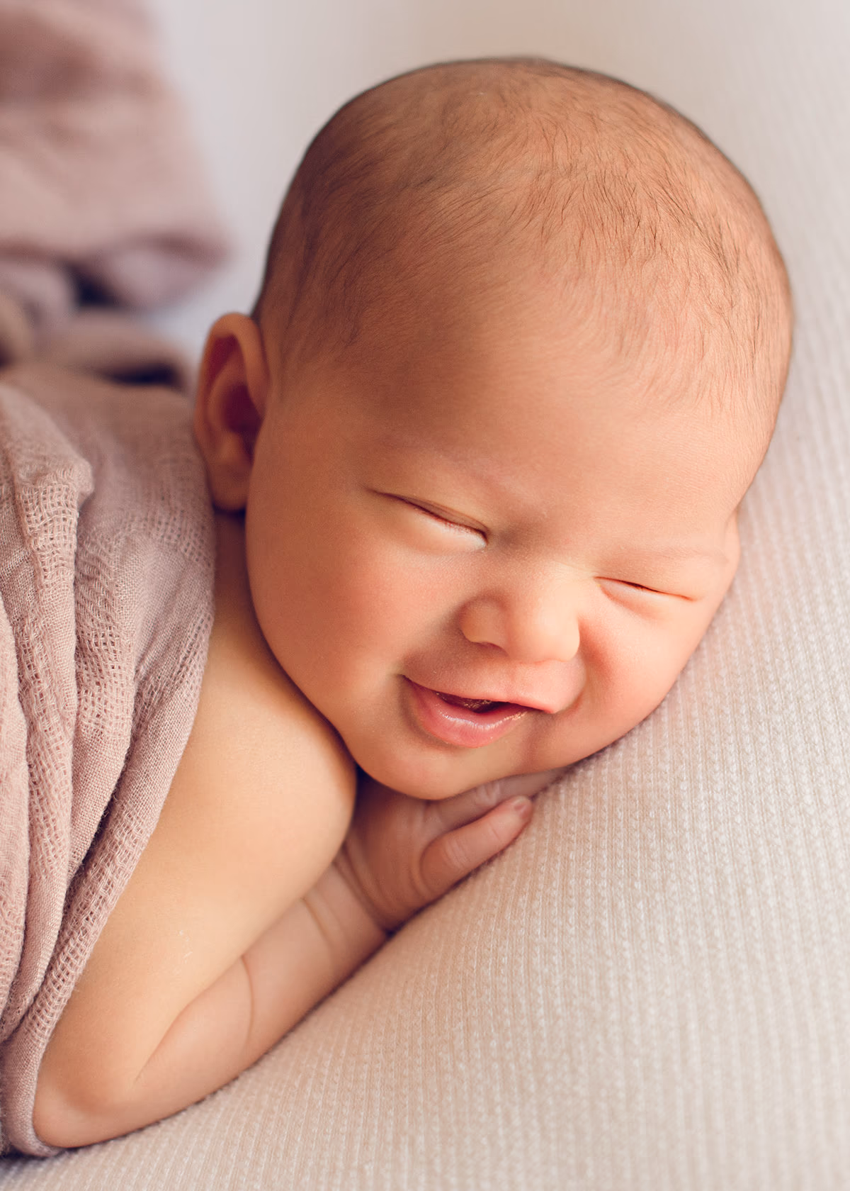 Newborn baby sleeping peacefully with a gentle smile during an in home session by Alicia Cervenka Photography